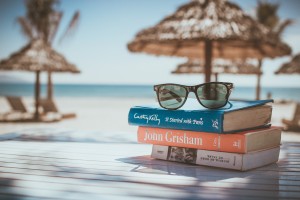 Image of beach with a few books and sunglasses